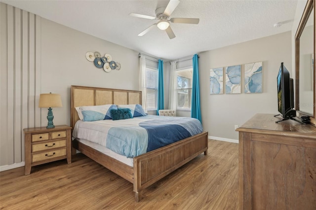 bedroom with light wood-type flooring, a textured ceiling, and ceiling fan