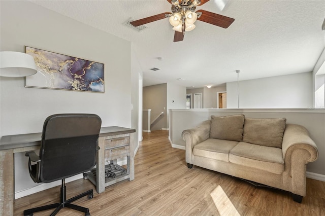 office space with ceiling fan, light wood-type flooring, and a textured ceiling