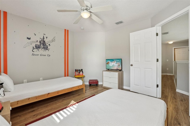 bedroom featuring hardwood / wood-style flooring, ceiling fan, and a textured ceiling