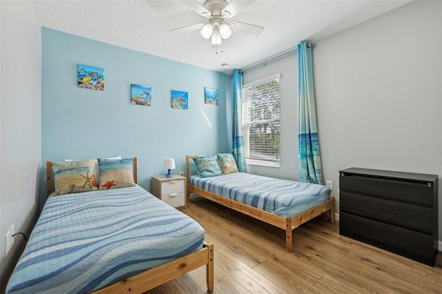 bedroom featuring a textured ceiling, ceiling fan, and light hardwood / wood-style flooring