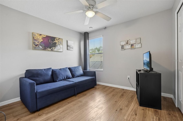 sitting room with hardwood / wood-style floors, ceiling fan, and a textured ceiling