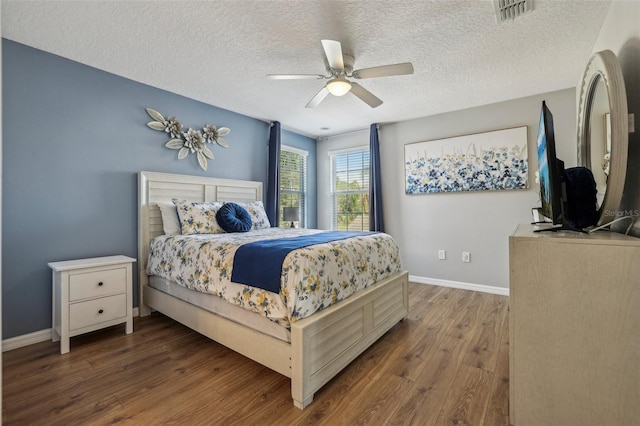 bedroom with dark hardwood / wood-style flooring, ceiling fan, and a textured ceiling