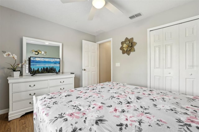 bedroom with dark hardwood / wood-style flooring, ceiling fan, and a closet