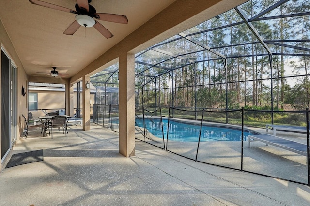 view of swimming pool featuring ceiling fan, a patio, and a lanai