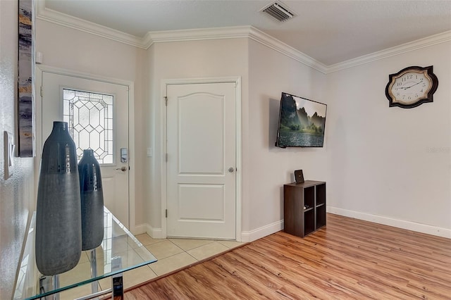 entryway featuring ornamental molding and light hardwood / wood-style floors