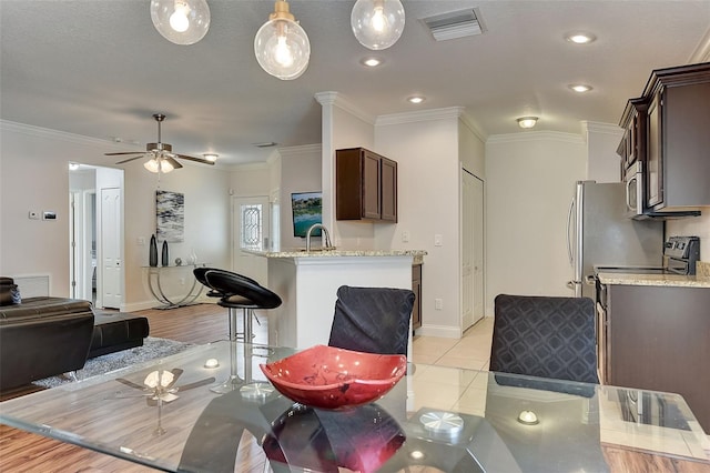 interior space featuring ornamental molding, light tile patterned floors, and ceiling fan