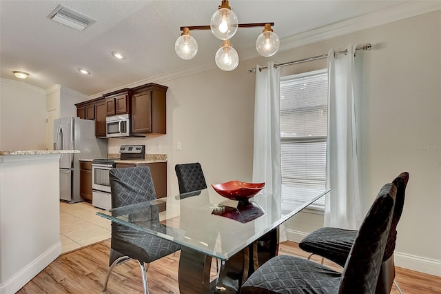 dining space featuring crown molding and light wood-type flooring