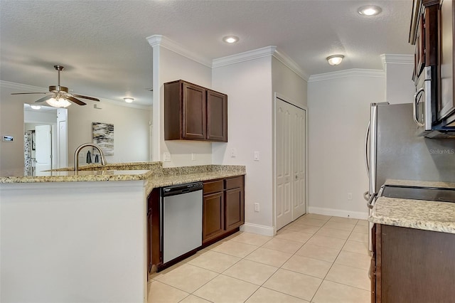 kitchen featuring light tile patterned floors, crown molding, stainless steel appliances, light stone counters, and a textured ceiling