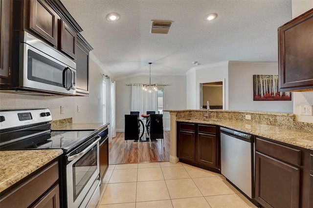 kitchen with light tile patterned flooring, pendant lighting, sink, stainless steel appliances, and crown molding