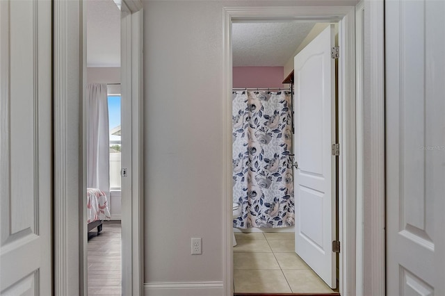 interior space featuring light tile patterned floors and a textured ceiling