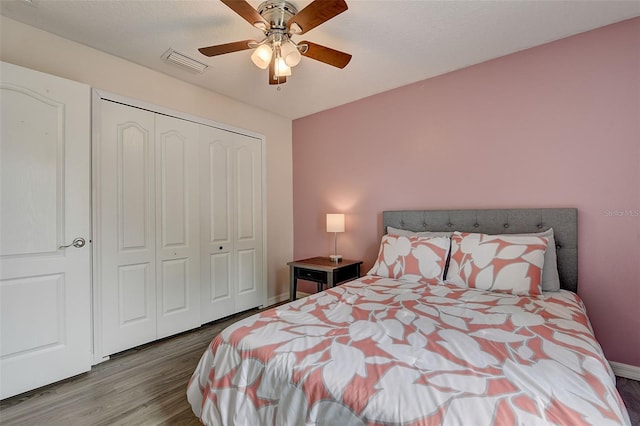 bedroom featuring hardwood / wood-style floors, ceiling fan, and a closet