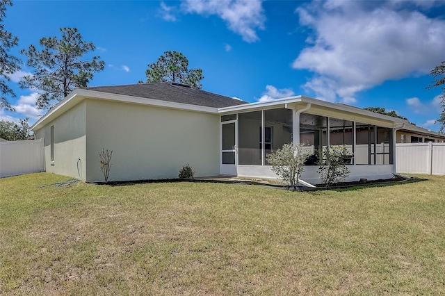 back of house with a sunroom and a yard