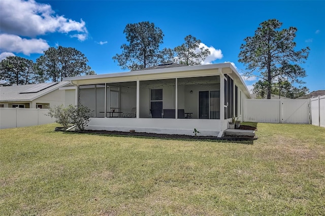 back of property with a yard and a sunroom