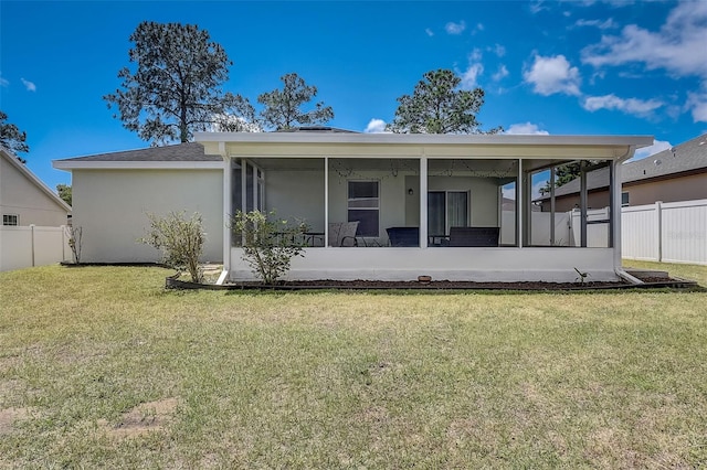 back of property featuring a sunroom and a yard