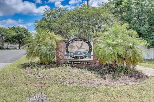 community / neighborhood sign featuring a lawn