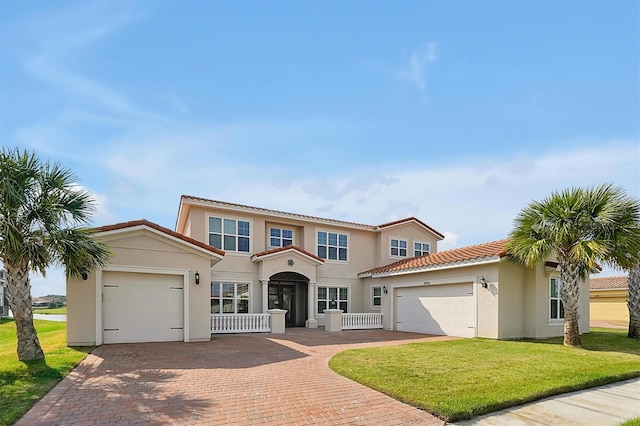 view of front facade with a front lawn, decorative driveway, an attached garage, and stucco siding