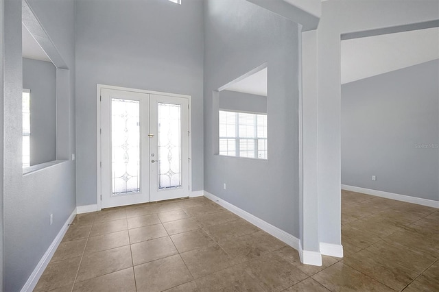 foyer featuring light tile patterned floors, baseboards, and french doors