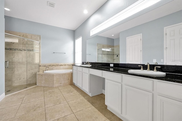 full bathroom featuring double vanity, visible vents, a sink, tile patterned flooring, and a bath