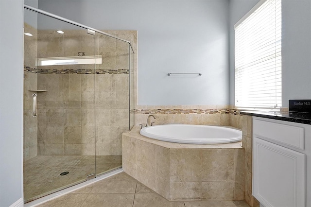 full bathroom featuring a stall shower, a garden tub, and tile patterned floors