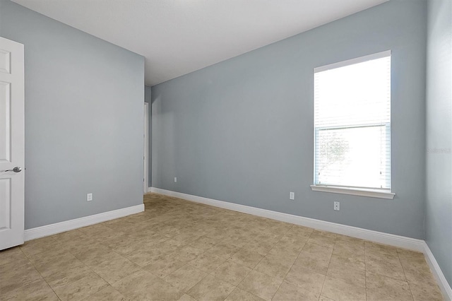 unfurnished room with baseboards