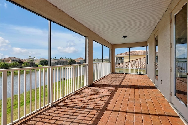 unfurnished sunroom with a water view