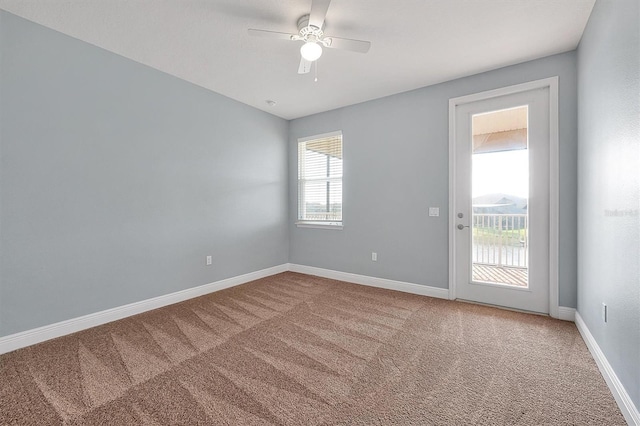 spare room featuring a ceiling fan, carpet, and baseboards