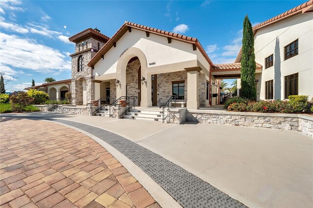 9918 Pallida Hickory Way, Winter Garden, FL 34787 - rear view of house with stucco siding, stone siding, and a tile roof