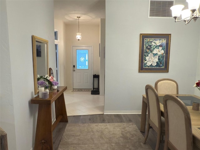 foyer with dark hardwood / wood-style floors and an inviting chandelier