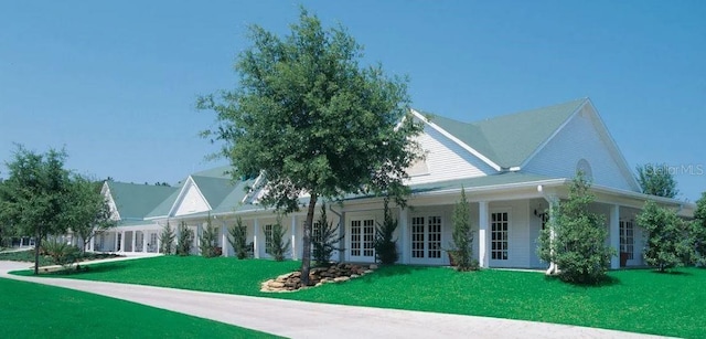 farmhouse-style home with a front yard and french doors