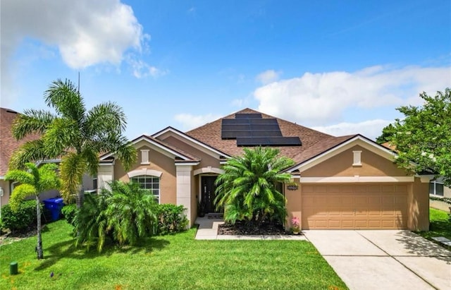 view of front of home with a garage, a front lawn, and solar panels