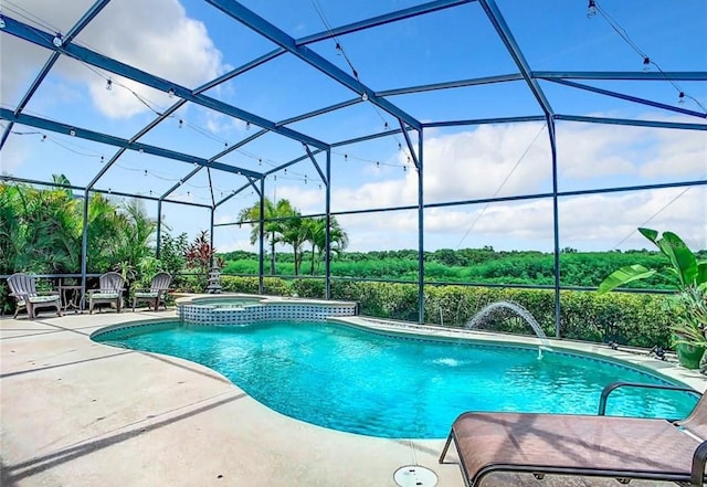 view of pool with an in ground hot tub, pool water feature, a patio area, and glass enclosure