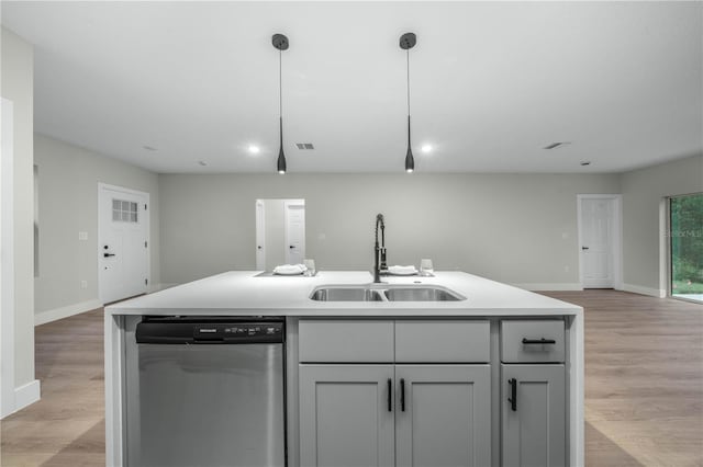 kitchen featuring open floor plan, light countertops, a sink, and stainless steel dishwasher