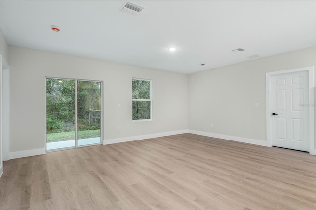 unfurnished room with baseboards, visible vents, and light wood-style floors