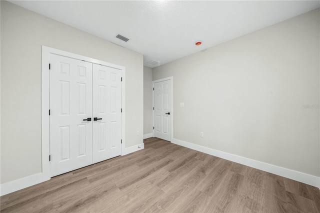 unfurnished bedroom featuring light wood-type flooring, visible vents, and baseboards