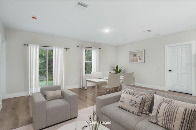 living area with light wood finished floors, baseboards, visible vents, and recessed lighting