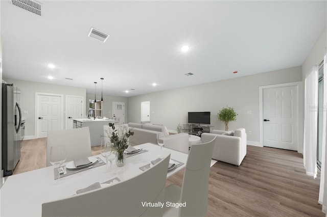 dining room with light wood-type flooring, visible vents, baseboards, and recessed lighting