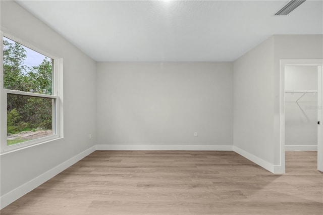 additional living space with light wood-type flooring, visible vents, and baseboards