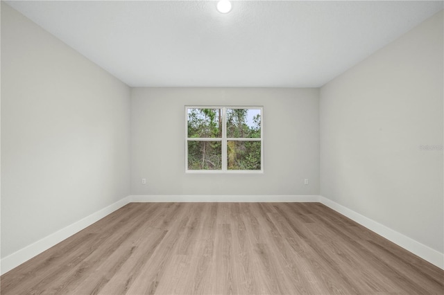 empty room featuring light wood finished floors and baseboards