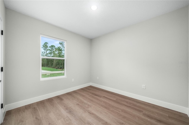 unfurnished room with light wood finished floors and baseboards