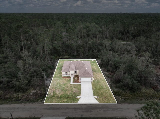 birds eye view of property featuring a forest view