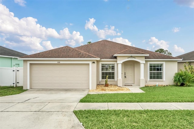 ranch-style home featuring a garage and a front lawn