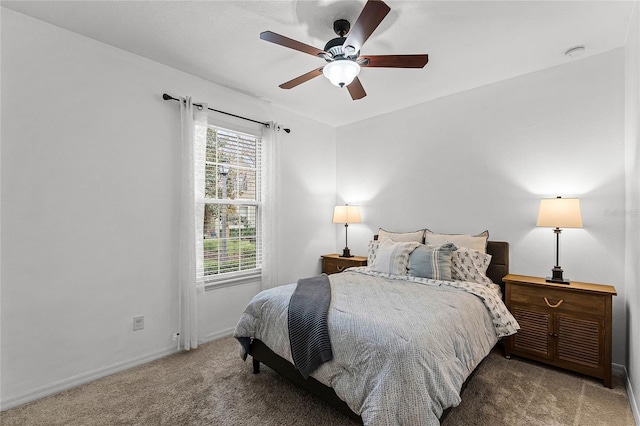 bedroom with baseboards, dark colored carpet, and a ceiling fan