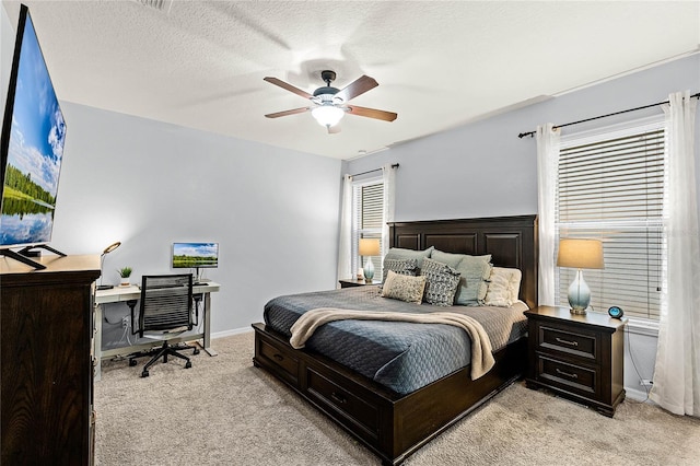 bedroom featuring light carpet, ceiling fan, a textured ceiling, and baseboards