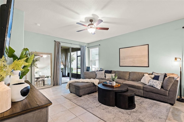 living area featuring ceiling fan, a textured ceiling, and light tile patterned floors