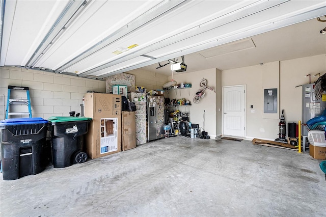 garage with electric panel, stainless steel refrigerator with ice dispenser, and a garage door opener