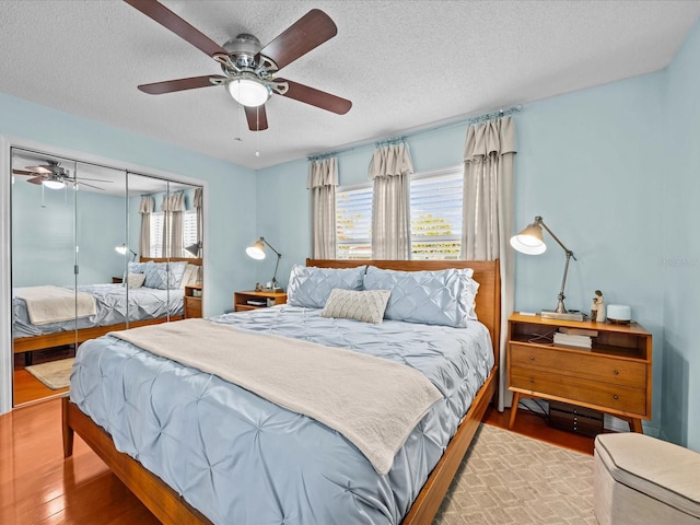 bedroom with ceiling fan, a textured ceiling, a closet, and hardwood / wood-style floors