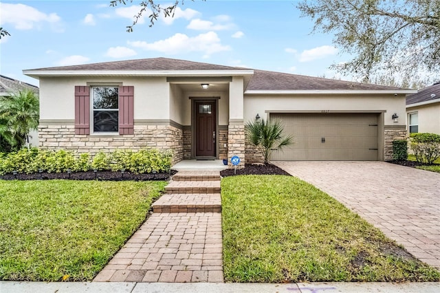 prairie-style home featuring a garage, stone siding, decorative driveway, and stucco siding