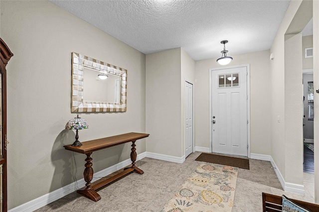 entryway featuring a textured ceiling, visible vents, and baseboards