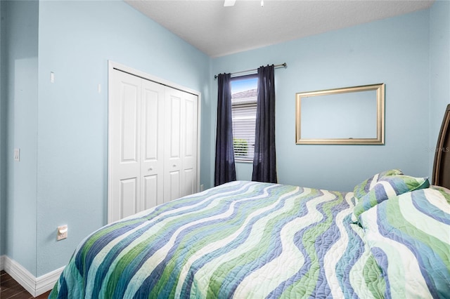 bedroom featuring baseboards, a ceiling fan, wood finished floors, a textured ceiling, and a closet