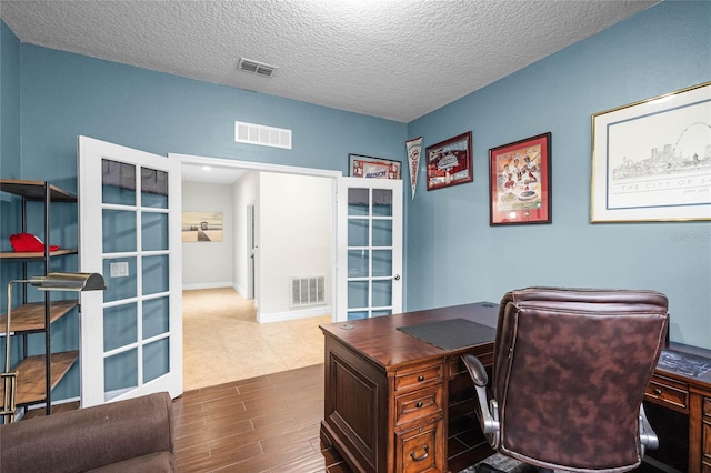 office space with french doors, visible vents, and a textured ceiling